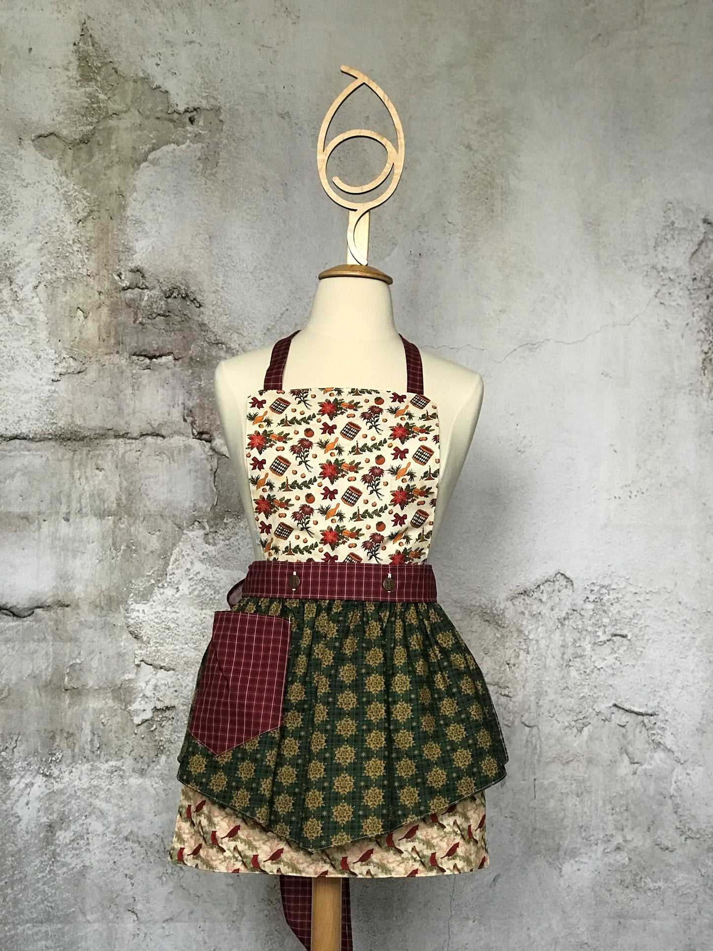 Deby’s Diva Apron™ is a patent pending convertible kitchen apron that can be worn 24 different ways by using the buttons on the waistband to flip, add or subtract the bib and both apron front and back. Featuring generously sized pockets, 100% high quality cotton fabric, and long waist and neck ties to make this apron well suited for most figures. Old-fashioned Christmas prints that include drums, horns, poinsettias, cardinals, holly and snowflakes.